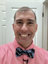a man in a pink shirt with a bow tie